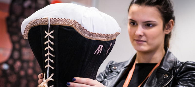 Photo of woman holding a corset.