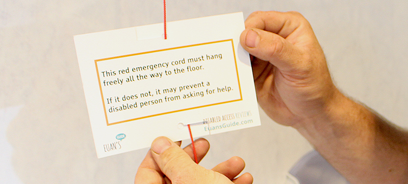 Someone holding a Red Cord Card attached to a red emergency cord