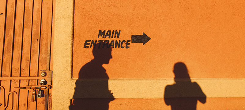 Exterior or restaurant with people's shadows against the wall.