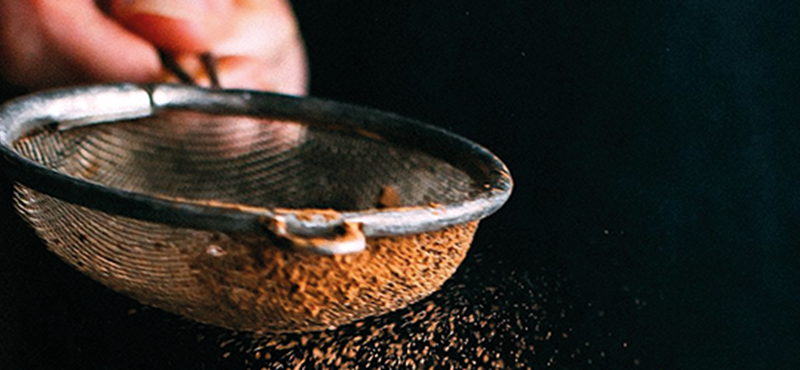 Image of someone sifting cocoa powder