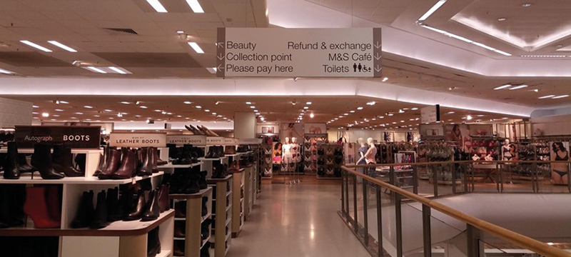 Inside a store with clear pathway and signage pointing to the toilets and other areas of interest.