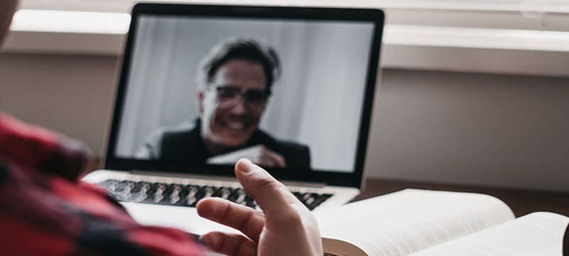 Image of two people talking over video chat on a laptop.