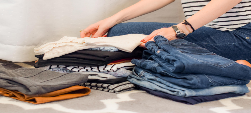 Image of a person folding and organising clothes.