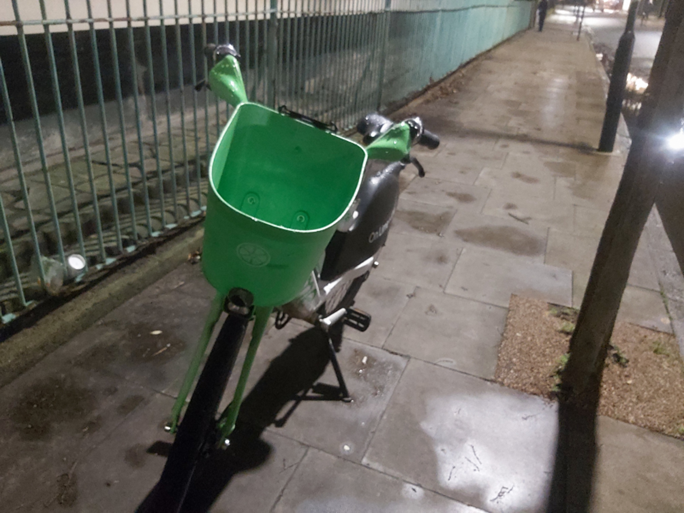 A bicycle parked in the middle of a pavement blocking the way