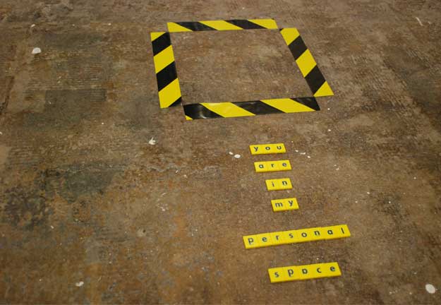 A photo of some writing on the floor which reads 'you're in my personal space',