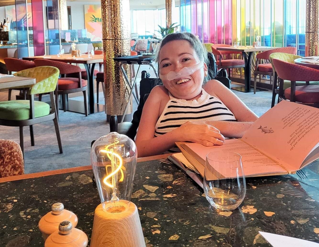 A photo of Claire in a stripey top at a restaurant table