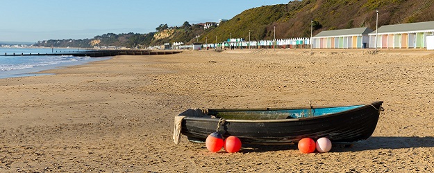 Photo of a boat on a sandy beach.