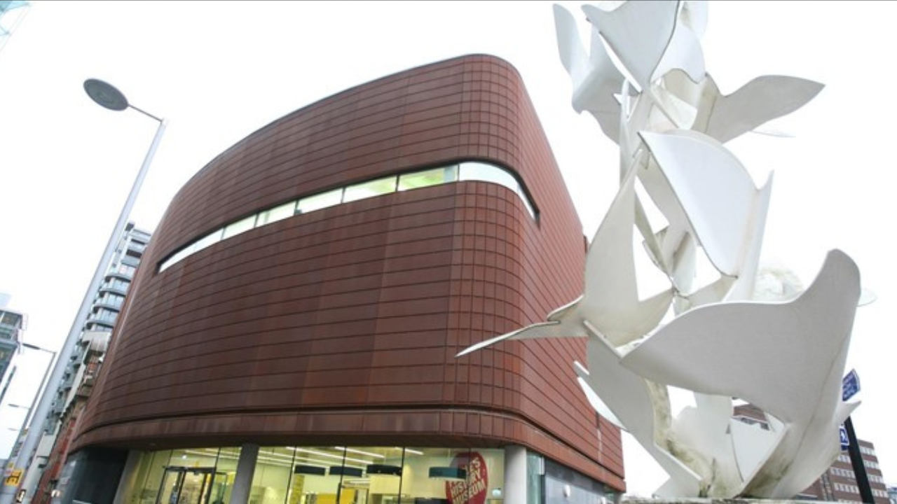 The exterior of the People's History Museum, a modern red-brick and glass building with large windows.