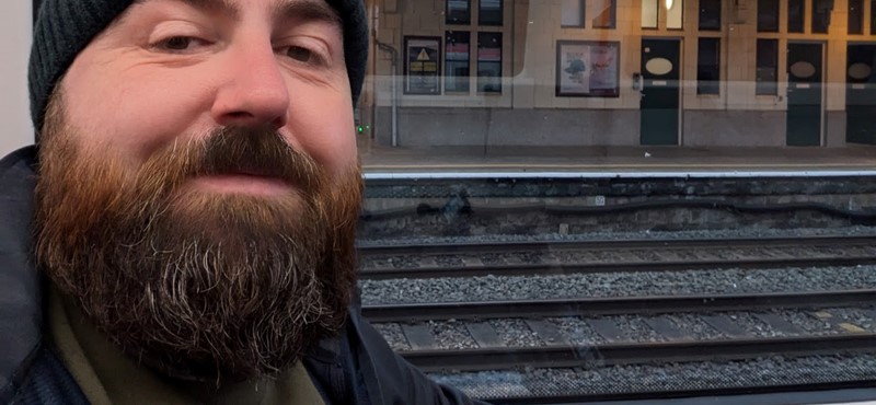 A selfie of Joe at a train station