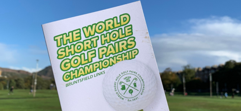 A photograph of the golf brochure with the title The World Short Hole Golf Pairs Championship on it.