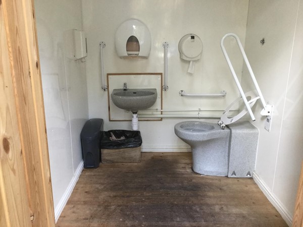 Disabled toilet in wooden hut.