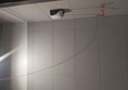 Image of a white tile wall with a red emergency cord attached to it