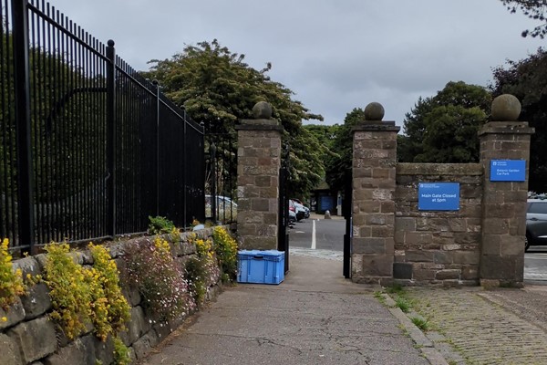 Image of a stone gate with a blue sign