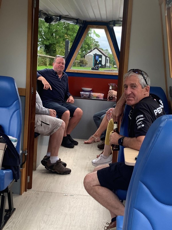 Picture of people sitting inside a narrow boat