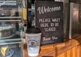 Image of Vienna branded coffee cup on the counter by the welcome sign