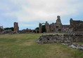 Priory grounds with ruins in the background and grass surface.