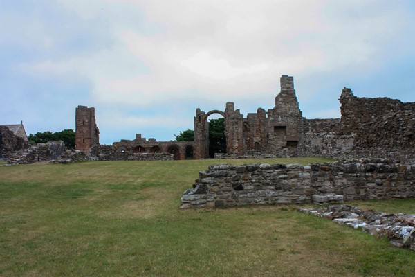 Priory grounds with ruins in the background and grass surface.