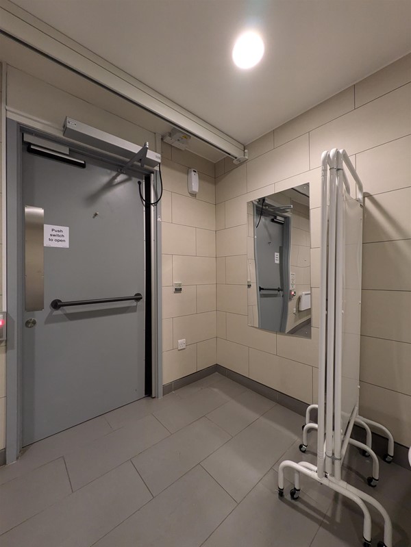 Image of the door to the toilet, mirror and privacy screen