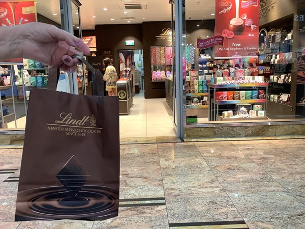 Picture of someone holding up a Lindt bag outside Lindt