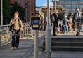 Image of the step and ramp access, as well as the tap in/tap out terminal. People gather on the platform.