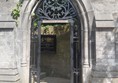 Image of a stone archway with a black gate