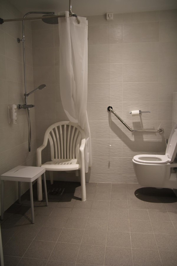 bathroom with bath stool and requested chair with arms