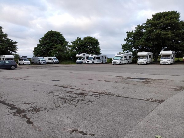 Huge car park with several motorhomes around the edge.