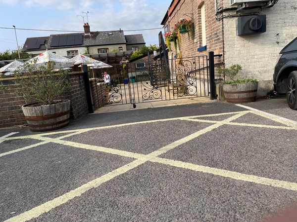 Image of a gated driveway with a fence and plants