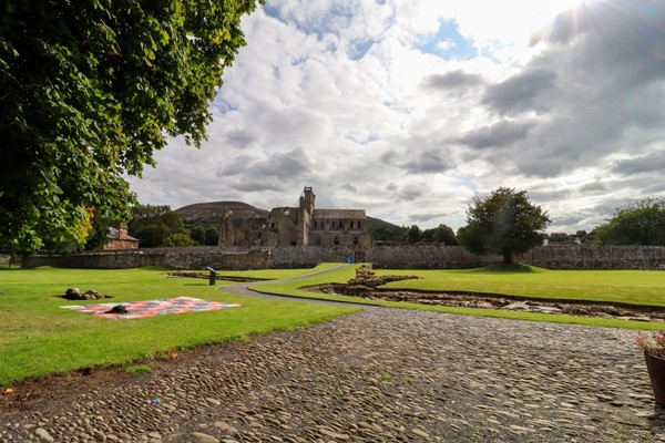 Museum grounds with cobbles and a rough path up to the gate.