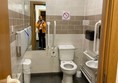 Image of a person taking a photograph in an accessible toilet