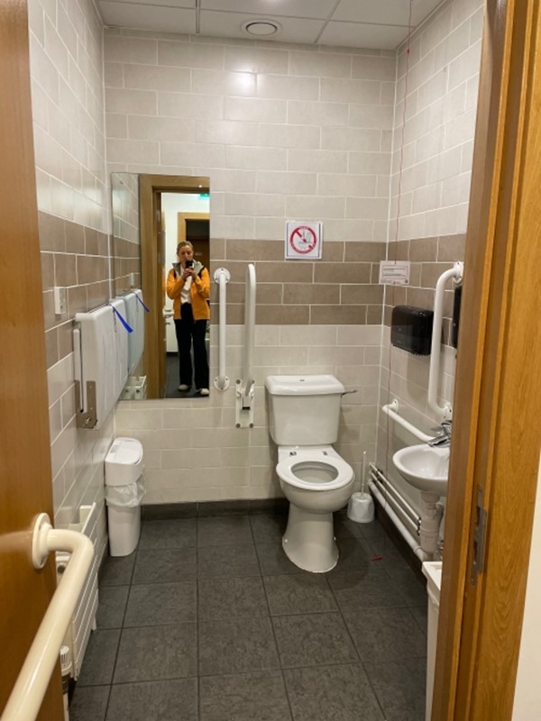 Image of a person taking a photograph in an accessible toilet