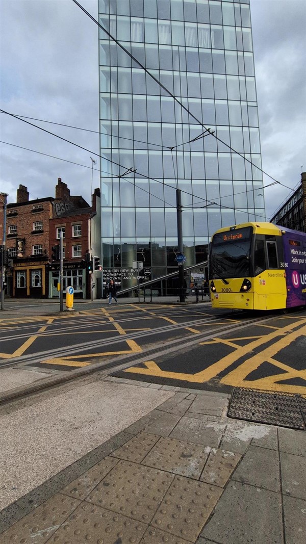 Image of a yellow tram on approach to the Metrolink