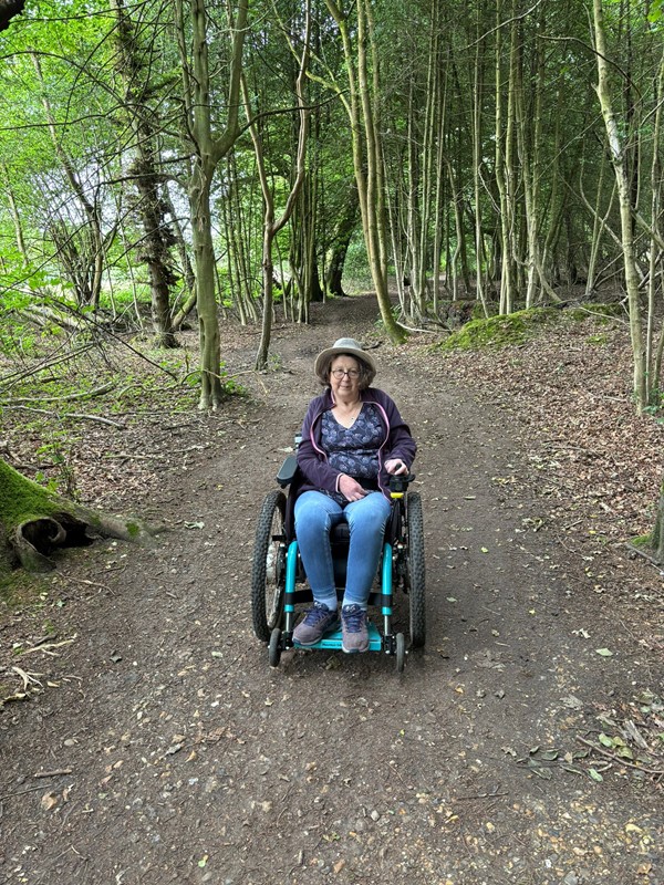 Image of a wheelchair user on awoodland path