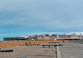 If you're standing here on the promenade at Poniente beach, you're facing the right way to reach the beach wheelchair station. Keep going around the promenade until you reach the end,  The hut is in front of the large concrete building with the word on it that you can see in the distance.