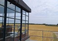 Image of a building with windows and a field of wheat