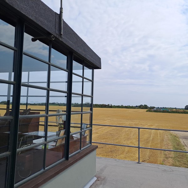 Image of a building with windows and a field of wheat