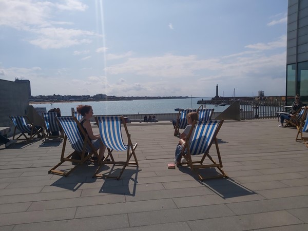 Image of people sitting in chairs on a deck