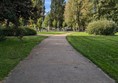 Image of a flat path bordered by grass and trees