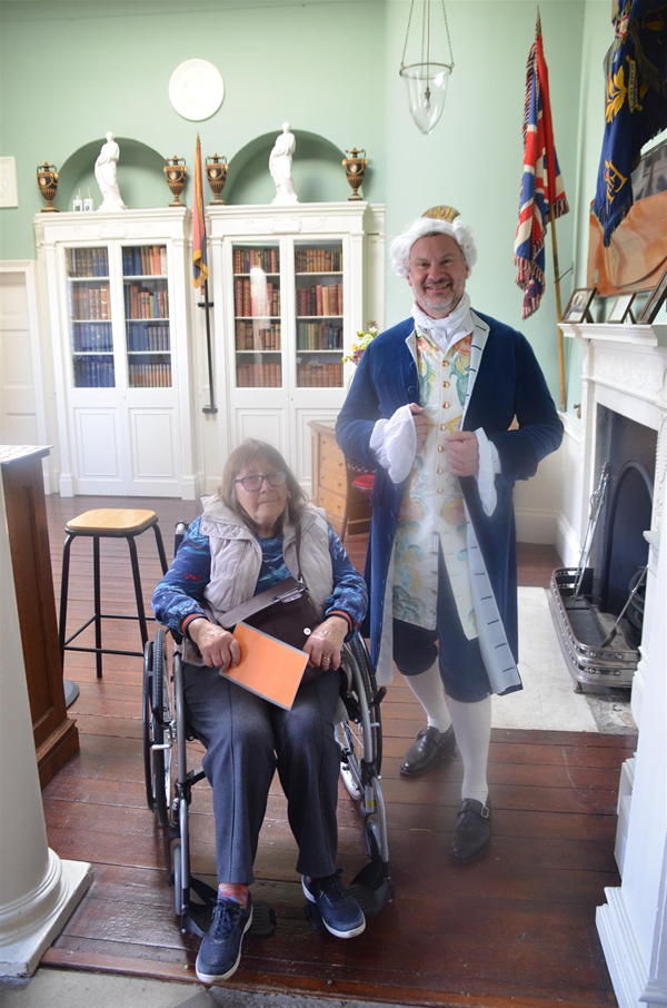 Image of a person in a wheelchair by a person in fancy dress