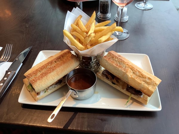 A very large steak sandwich and french fries