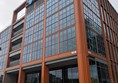 Exterior image of the Barclays Campus Building "The Street". A large copper-toned building, over 5 floors with the Barclays logo in blue at the top of the building.