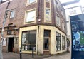 Picture of the front of the exchange from the pavement Infront. Both entrances are visible from the front, the one on the corner of the building is open during the day, and the larger door on the left is open during events. When going to a show, queue up on the left.