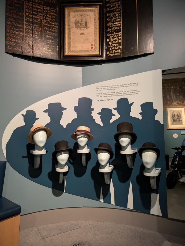 Image of an exhibit showing mannequin heads wearing different hats