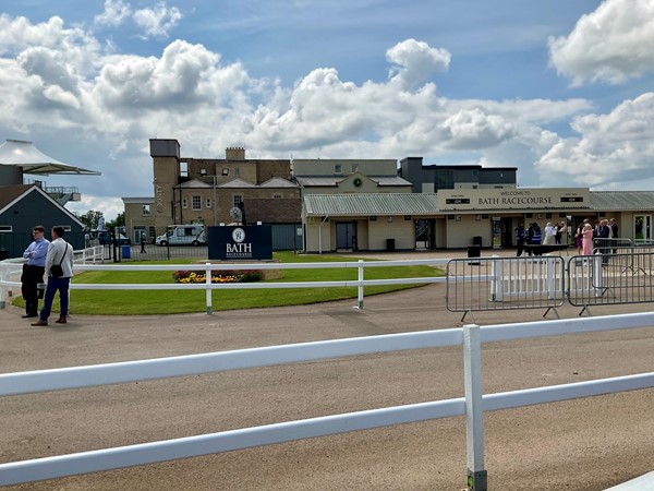 Image of a horse race track with a building and a fence