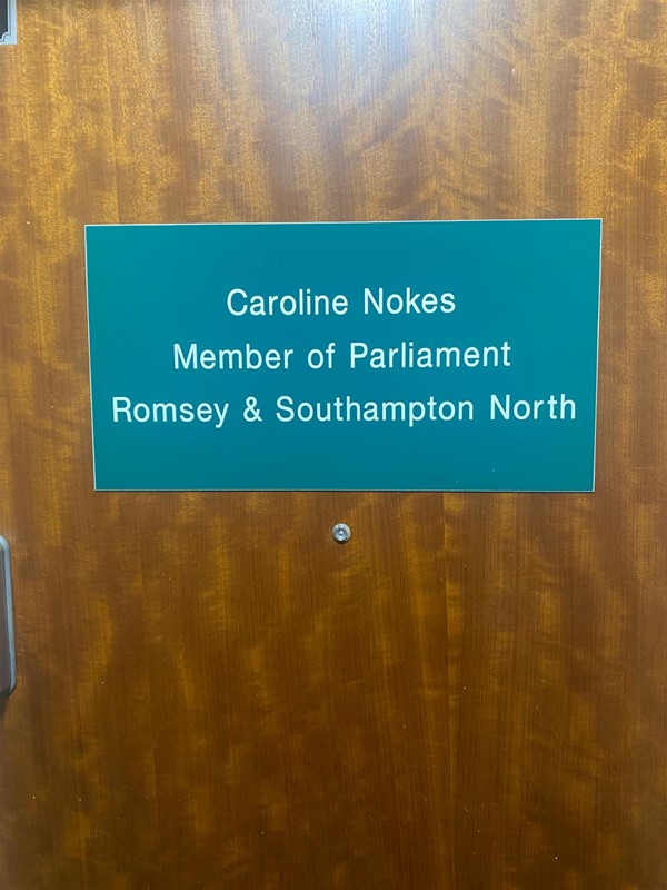 Image of a green sign with white writing on a door