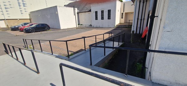 Image of three disabled parking bays with ramp and rails.