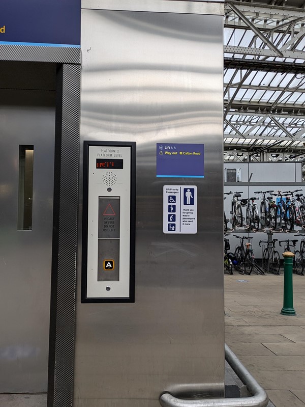 Image of the outside of a lift in the station, there are Braille buttons on the panel.