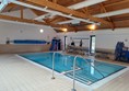 An indoor pool with a metal railing