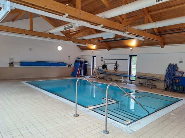 An indoor pool with a metal railing