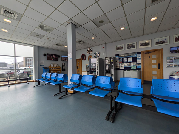 Image of the seating area, a row of blue plastic seats